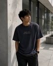 Male model wearing the Shevelo Cuda out of memory heavyweight oversized tee in Faded Black.