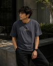Male model wearing the Shevelo Resolve manually heavyweight oversized tee in Faded indigo.