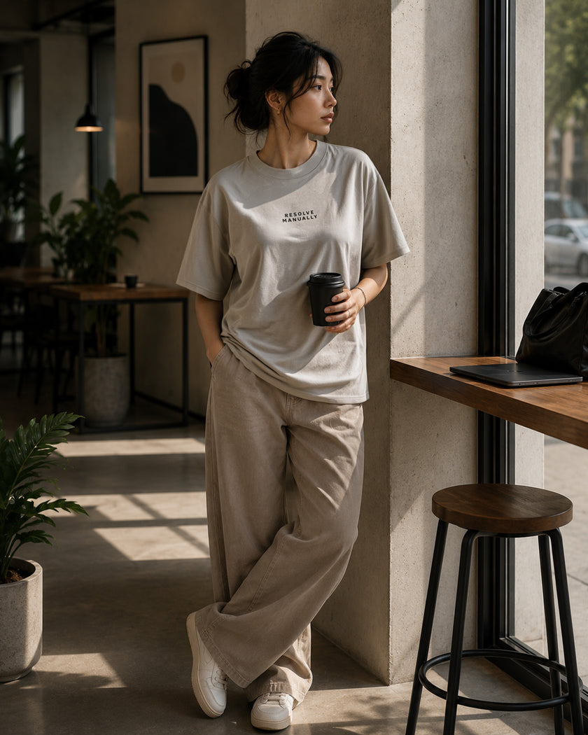 Female model wearing the Shevelo Resolve manually heavyweight oversized tee in Faded Bone.