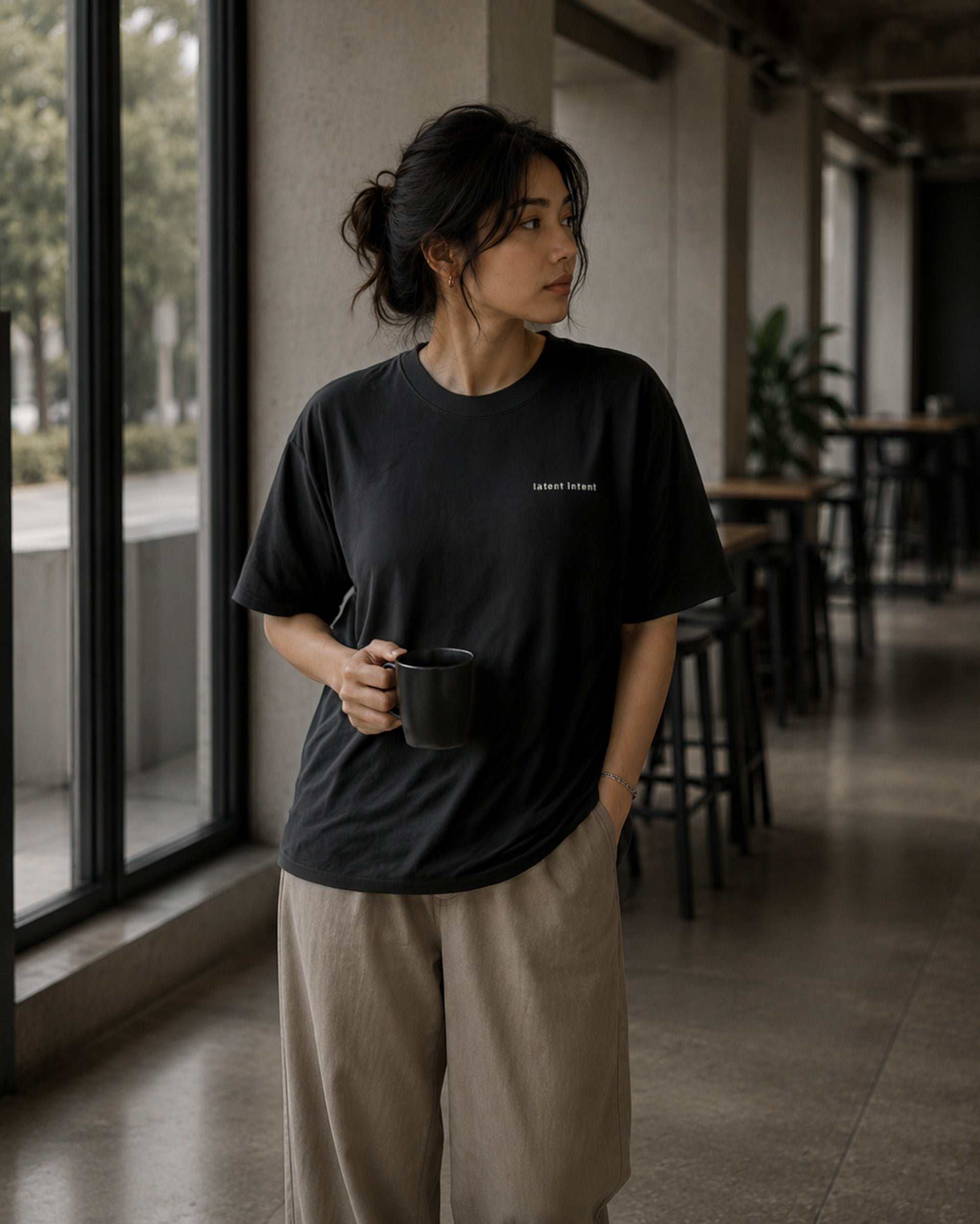 Female model wearing the Shevelo Latent intent heavyweight oversized tee in Faded black.