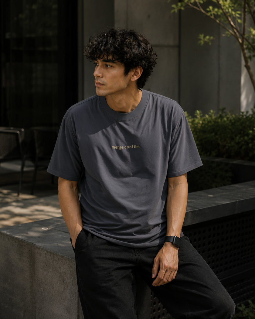 Male model wearing the Shevelo Merge conflict heavyweight oversized tee in Faded indigo.