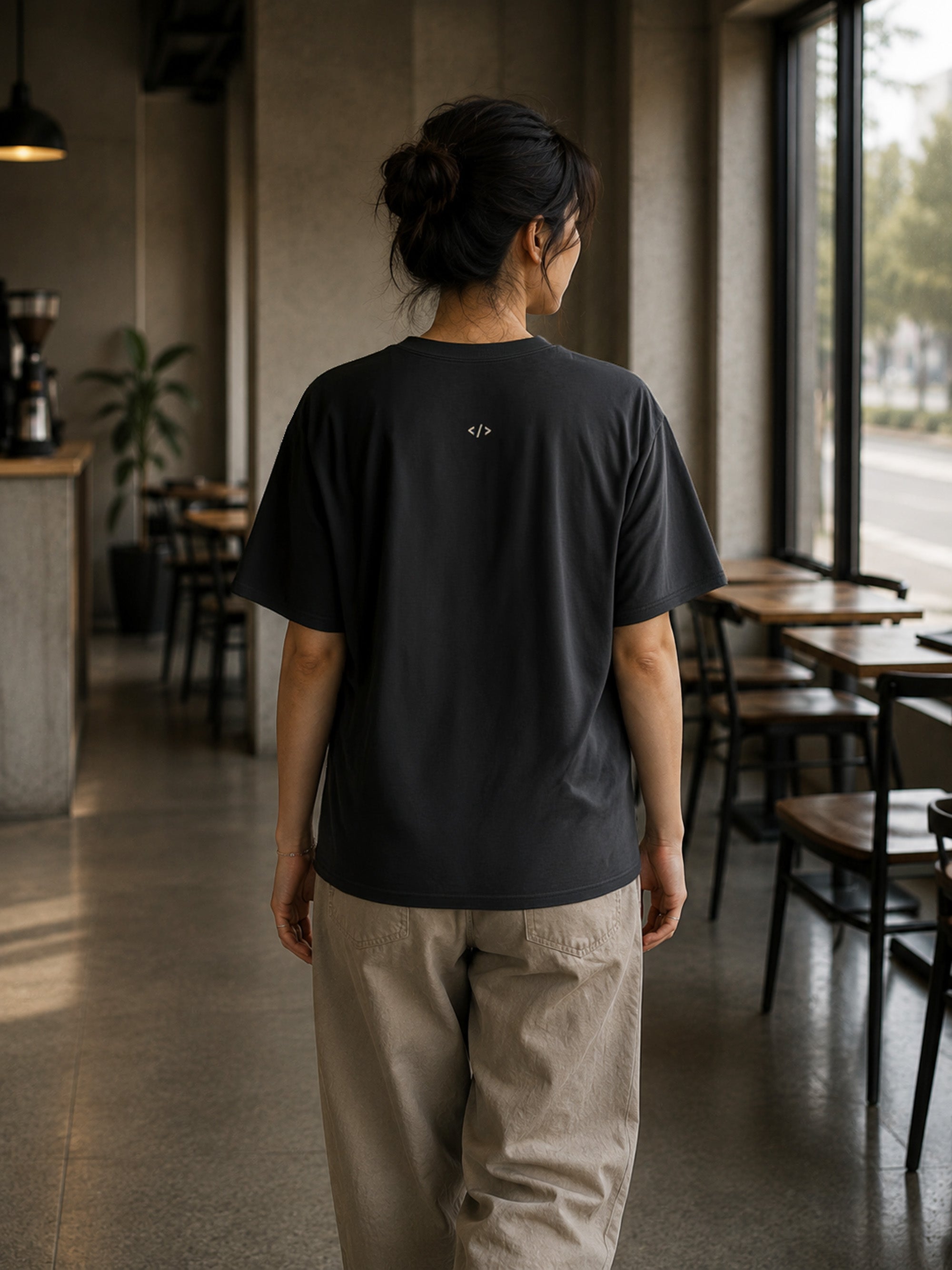 Rear view of the Shevelo Context overflow heavyweight oversized tee in Faded black showing the signature back graphic.