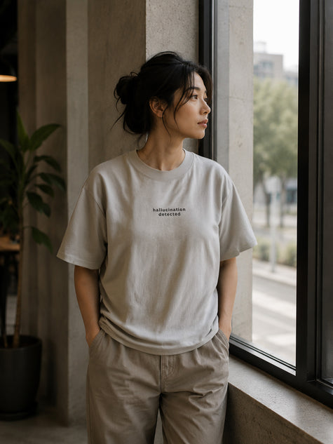 Female model wearing the Shevelo Hallucination detected heavyweight oversized tee in Faded Bone.