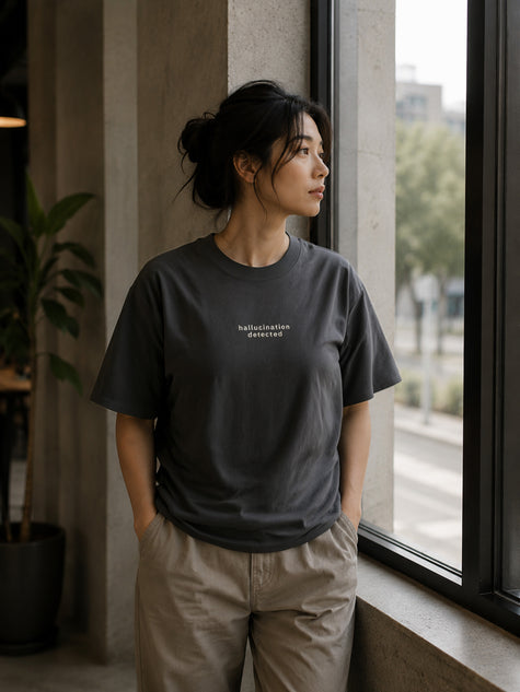 Female model wearing the Shevelo Hallucination detected heavyweight oversized tee in Faded black.