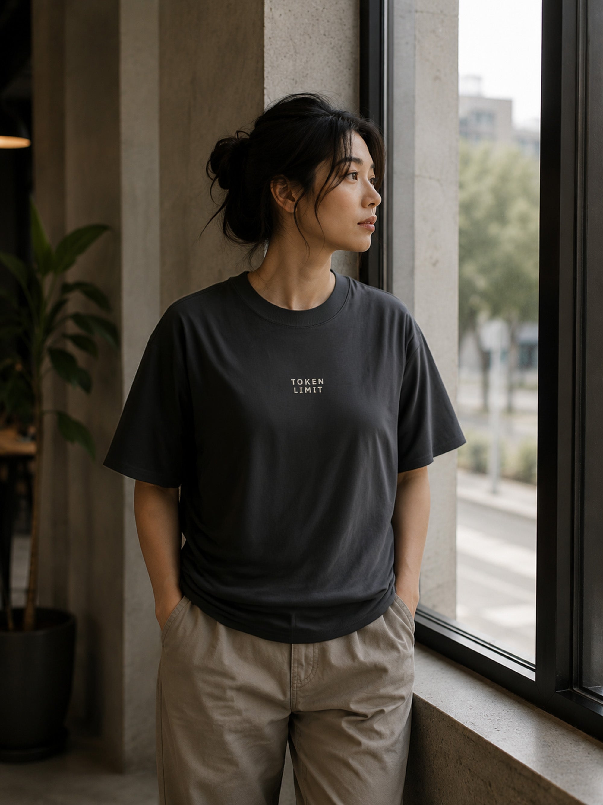 Female model wearing the Shevelo Token limit heavyweight oversized tee in Faded black.